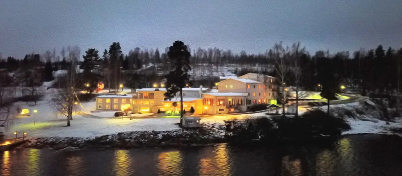 Hotellbyggnad vid vattnet med upplysta fasader och ljusa fönster