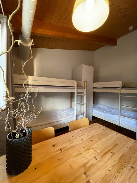 Rum med våningssängar och matbord på Ekeby Vandrarhem