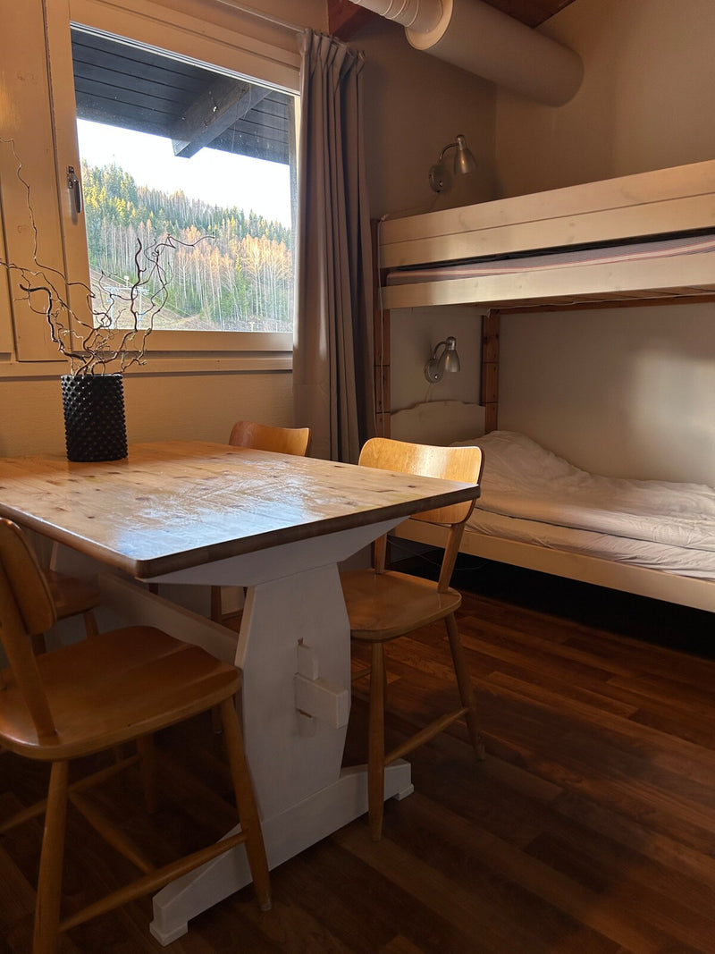 Rum med bord och fönster mot skogen på Ekeby Vandrarhem
