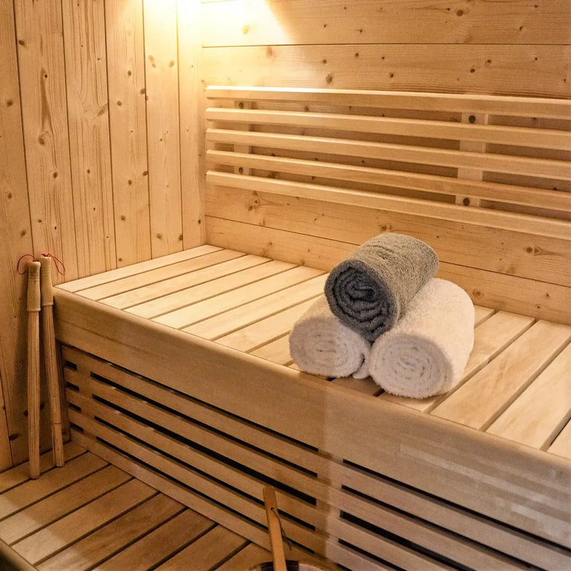 Hyra bastu: träbastu med sittbänk och vikta handdukar på bänken